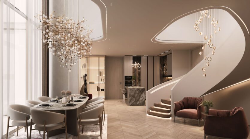 A sleek, modern dining and living room, The Symphony features a marble table, plush chairs, a sculptural chandelier, a grand staircase with gold accents and soft, neutral tones throughout.