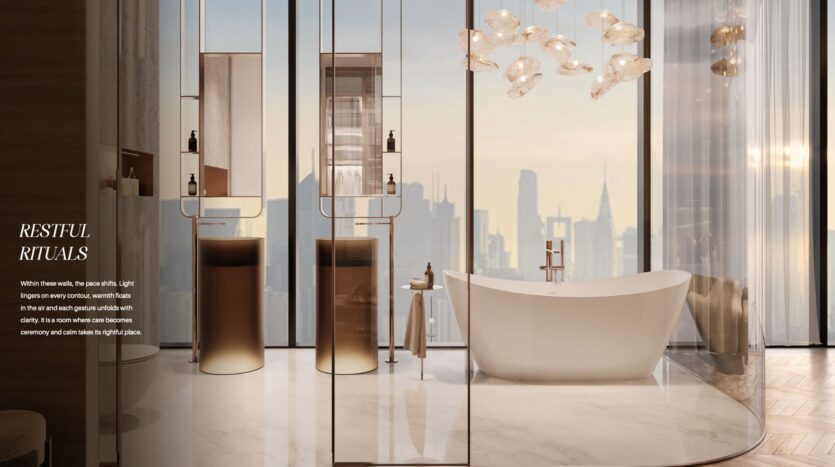 The luxurious bathroom, christened The Symphony, features a freestanding bathtub, two sinks with bronze accents, floor-to-ceiling windows with horizon views, elegant lighting and marble floors. The text on the left reads "Restful Rituals".