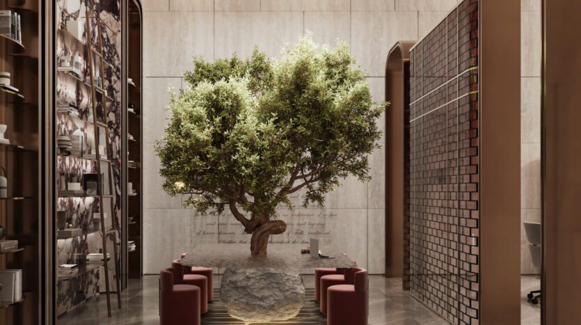 A large tree grows in the center of a long stone table in The Symphony, surrounded by red upholstered chairs in a modern, elegant room with high shelves and marble walls.