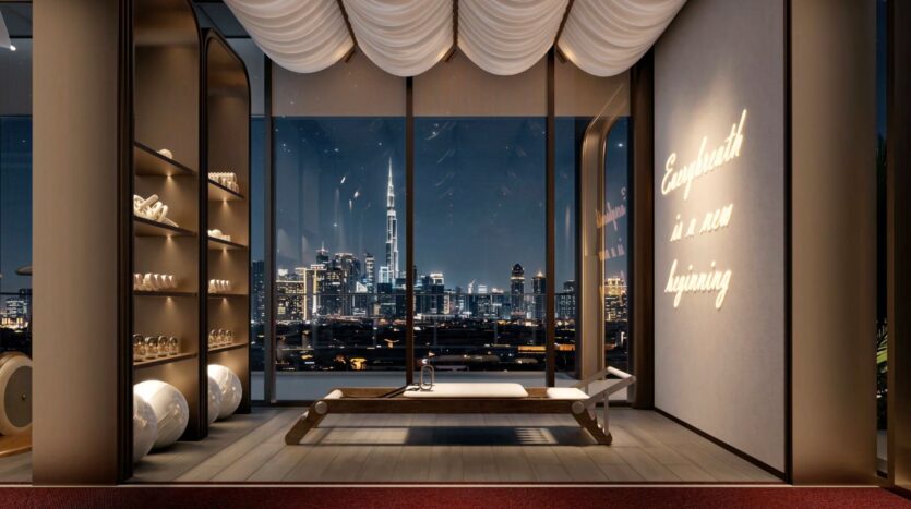 A modern yoga studio with floor-to-ceiling windows overlooking the city skyline at night, with a central yoga mat, shelves with towels and bright wall text that reads "Every breath is a new beginning" - a true symphony of tranquility.
