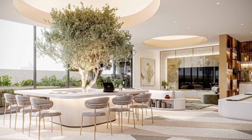 Modern and airy living room at Arlington Park 2, featuring a large tree growing through a central island table surrounded by stylish chairs. Floor-to-ceiling windows flood the space with natural light, while neutral tones and contemporary décor create a serene atmosphere.