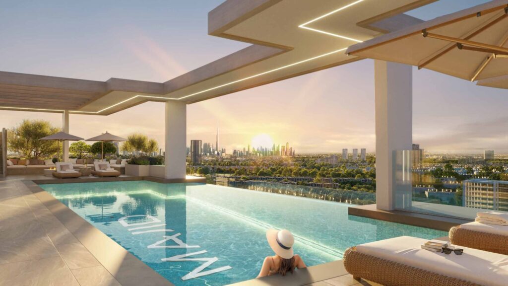 A person wearing a sun hat relaxes in a rooftop infinity pool at sunset, overlooking the skyline of modern Arlington Park 2, with lush greenery and elegant relaxation areas nearby.