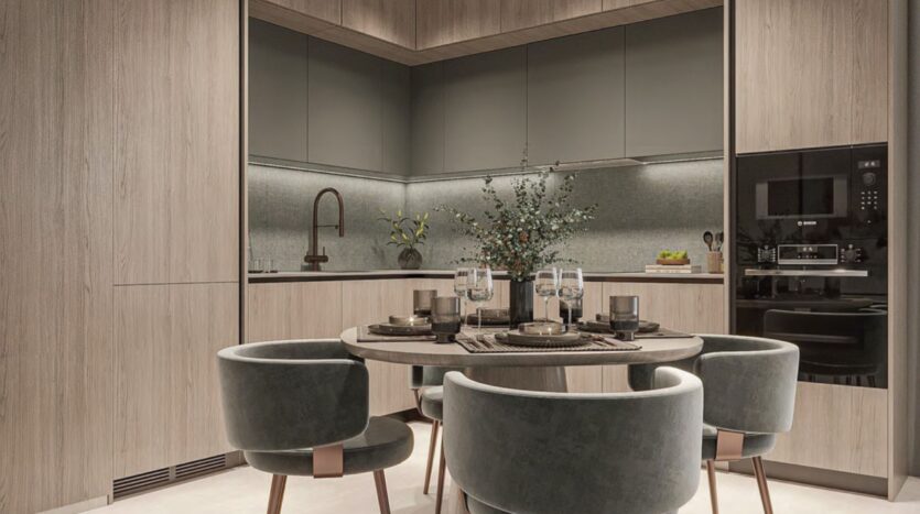 Cucina moderna con mobili in legno, tavolo rotondo per quattro persone, sedie in velluto, elettrodomestici da incasso e un vaso centrale con rami verdi. Lo spazio è caratterizzato da tonalità neutre e una morbida illuminazione d'atmosfera di Floarea Breeze.