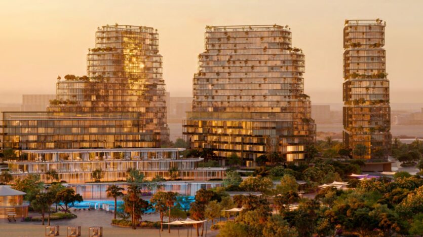 At sunset, Hado's modern skyscrapers with glass facades and greenery stand among the trees, reflecting warm light. A swimming pool and landscaped outdoor areas are visible in the foreground, creating a lush urban atmosphere.