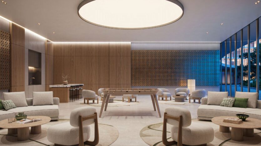 A modern lounge with neutral-toned sofas and chairs, round wooden tables, a foosball table in the center, wood-paneled walls, and large floor-to-ceiling windows to let in natural light creates the perfect retreat inspired by the Hado universe.
