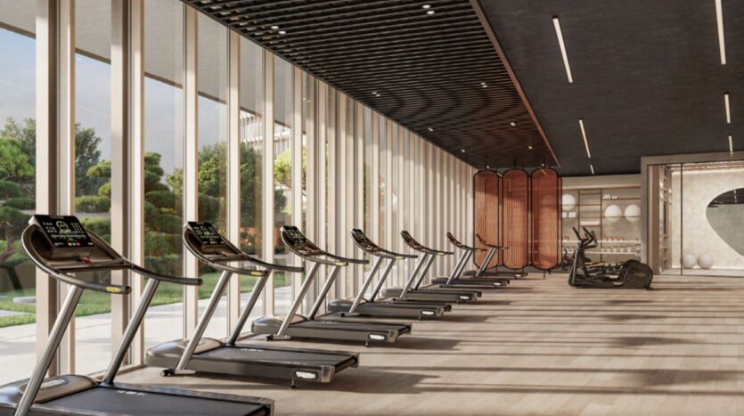 A modern gym with minimalist Hado-inspired decor, floor-to-ceiling windows, several treadmills lined up, and two exercise bikes in the background. The space is bathed in natural light and exudes elegant simplicity.