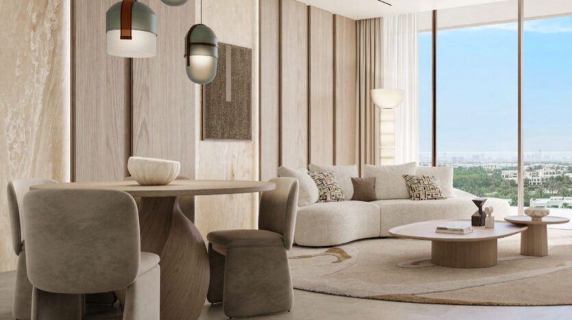 Modern living and dining room with neutral tones, a round Hado table and four chairs, a curved sofa, a patterned rug, and large windows overlooking an urban landscape and greenery, complemented by contemporary pendant lights and wall art.