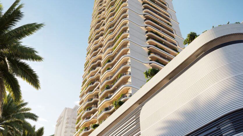 A modern tower, Alta View, with undulating balconies and lush vegetation on each floor, seen from below against a blue sky. Palm trees and another building frame this striking scene.