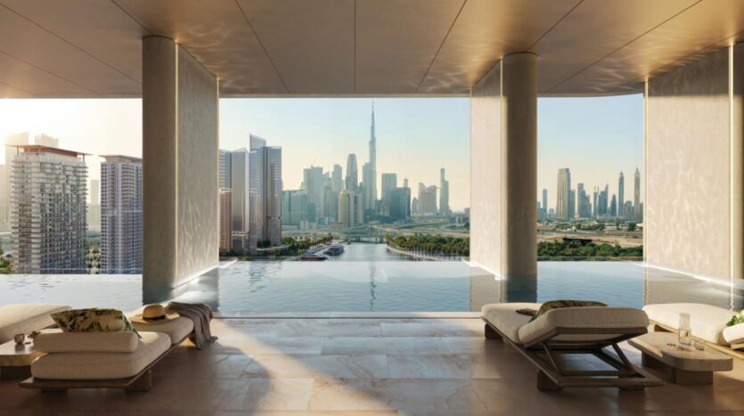 A luxurious indoor infinity pool with lounge chairs overlooks the city skyline featuring the Burj Khalifa, where sunlight streams in and modern design creates a serene atmosphere under clear skies.