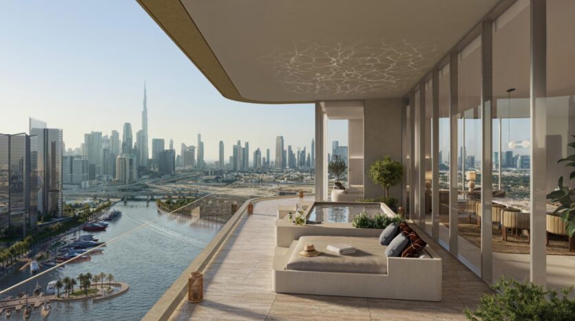 The luxurious terrace, featuring modern seating and a jacuzzi, overlooks a canal and the Dubai skyline, including the Burj Khalifa, under clear skies. Large glass doors reveal an interior living space that showcases refined art and elegance.