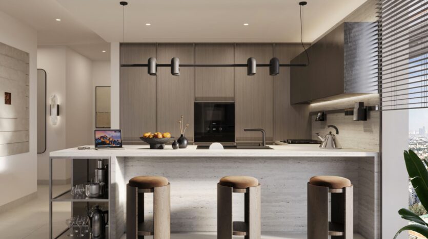 Modern kitchen with wooden cabinets, marble island, three padded bar stools, a laptop, a fruit bowl, and a kettle. Pendant lights hang above the island, while large windows offer natural views of the Eltiera and fill the space with light.