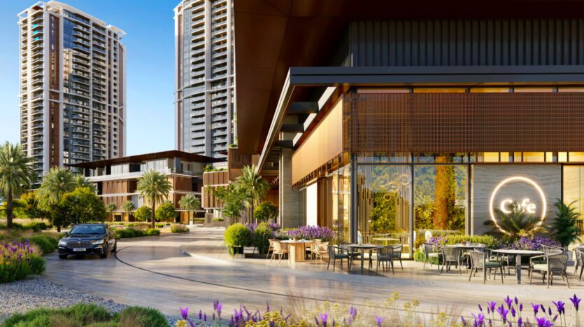 Modern urban scene with high-rise buildings, a stylish café with outdoor seating, lush landscaping, palm trees, and a car parked on a curved driveway, all set against views of Eltiera under a clear blue sky.