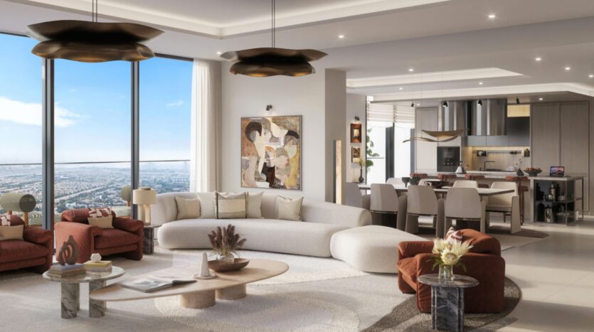 A modern and spacious living room with large windows offering breathtaking views of the Eltiera, a curved cream sofa, red armchairs, abstract artwork, an open kitchen, and a dining room decorated in neutral tones with contemporary lighting.