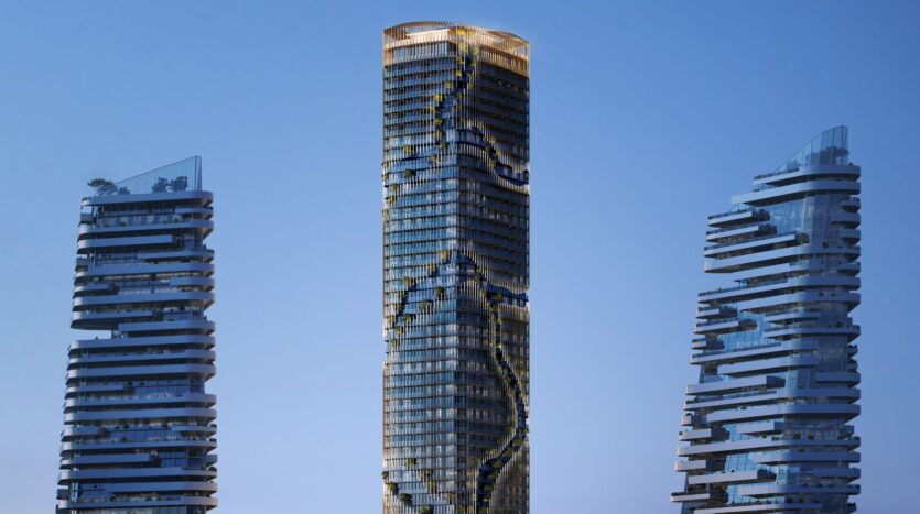 Three modern towers, reminiscent of the architectural style of Kanyon, feature unique, irregular balconies against a backdrop of clear blue skies. The central tower is distinguished by a sinuous pattern of gardens or terraces along its facade.
