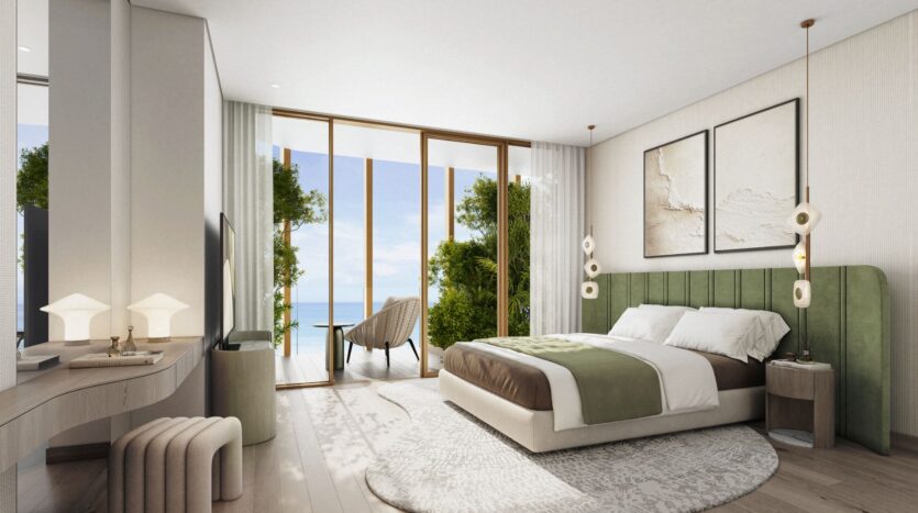 A modern Kanyon bedroom with a green upholstered bed, white and green bedding, large windows with sheer curtains, a balcony, two lounge chairs, and breathtaking views of the ocean and greenery outside.