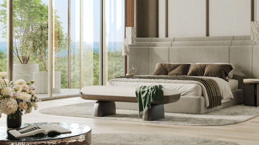 Modern bedroom with a large tufted bed, two brown pillows, a green throw, and an elegant bench at the foot of the bed. Floor-to-ceiling windows offer breathtaking views of the Kanyon. Fresh flowers decorate a round coffee table in the foreground.