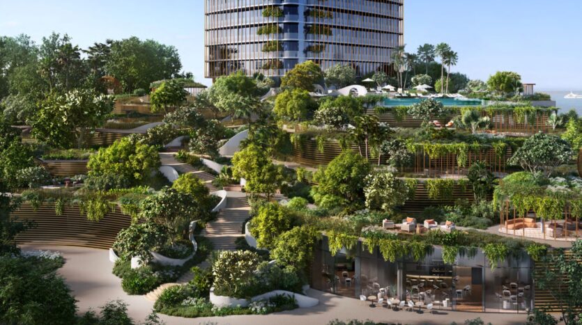 A modern Kanyon building with large windows rises above lush terraced gardens filled with trees and walkways. Outdoor seating areas are nestled among the greenery, creating a vibrant urban oasis.
