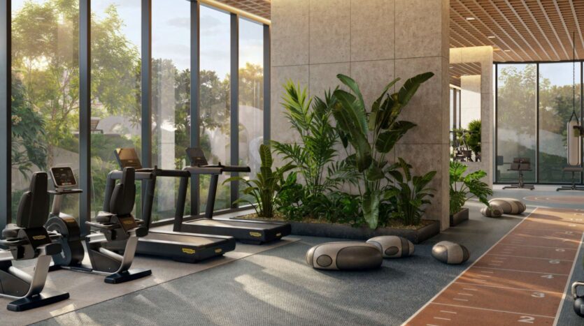 Kanyon's modern gym features large windows, treadmills, lush green plants, exercise equipment, and natural light that creates an open and welcoming atmosphere.