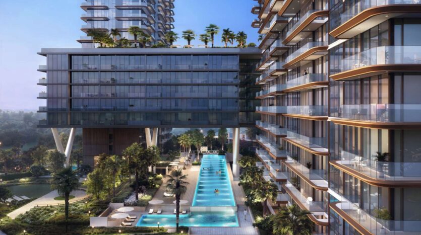Des tours d'habitation modernes avec des balcons en verre donnent sur une longue piscine extérieure entourée de palmiers, de chaises longues et de verdure dans l'environnement urbain luxueux de Soto Grande au coucher du soleil.