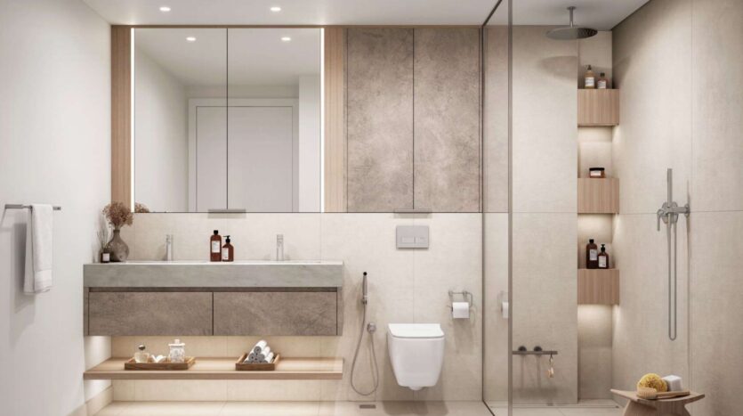 Salle de bains moderne de Soto Grande avec grand miroir, lavabo flottant, toilettes murales et douche en verre. Des étagères encastrées accueillent les articles de toilette et les serviettes. Les tons neutres et le design minimaliste créent un aspect propre et élégant.