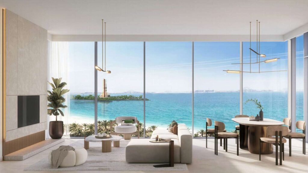 Le salon et la salle à manger modernes avec des fenêtres allant du sol au plafond offrent une vue panoramique sur l'océan Soto Grande, un mobilier neutre et élégant, des plantes d'intérieur et un phare lointain visible à travers l'eau turquoise.