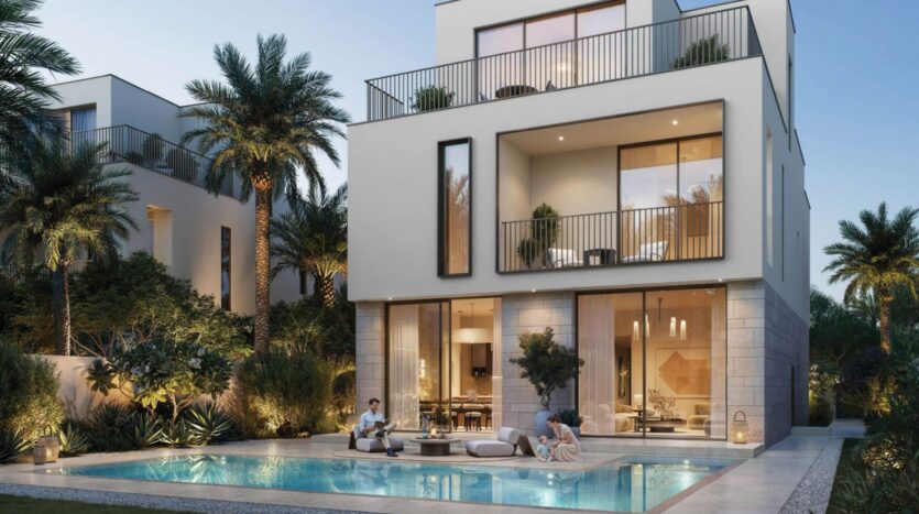 Modern three-story villa in The Heights, featuring large windows, balconies, and outdoor lighting, surrounded by palm trees and lush greenery. A couple relaxes by the pool, creating a luxurious and peaceful atmosphere at dusk.