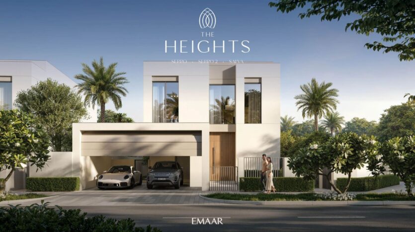 Modern two-story villa with large windows, a flat roof, and an attached two-car garage. Palm trees and greenery surround The Heights residence. A person stands near the entrance. The text reads "THE HEIGHTS" and "EMAAR."