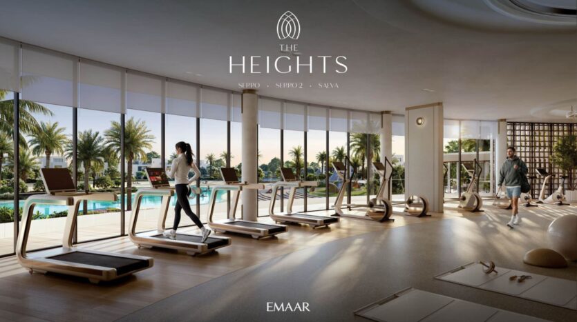 The modern gym at The Heights features large windows, treadmills, and fitness equipment overlooking a swimming pool and palm trees. Two people are exercising inside, bathed in natural light. The text reads "The Heights" and "EMAAR."
