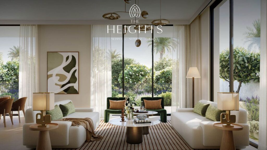 Modern living room in The Heights with two white sofas, green accents, a round coffee table, elegant lamps, abstract wall art, and large floor-to-ceiling windows overlooking a lush garden. The "The Heights" logo appears at the top center.