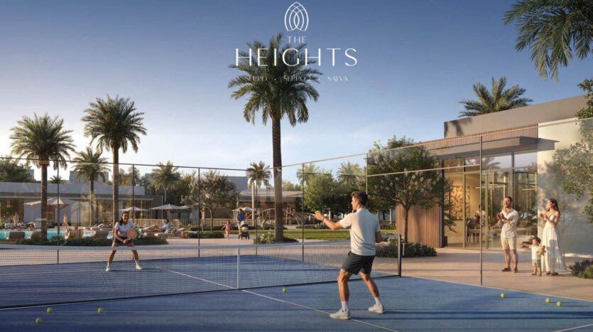 Two people play tennis on an outdoor court at The Heights, surrounded by palm trees and modern buildings, while a family watches over the surroundings in this luxurious residential community.