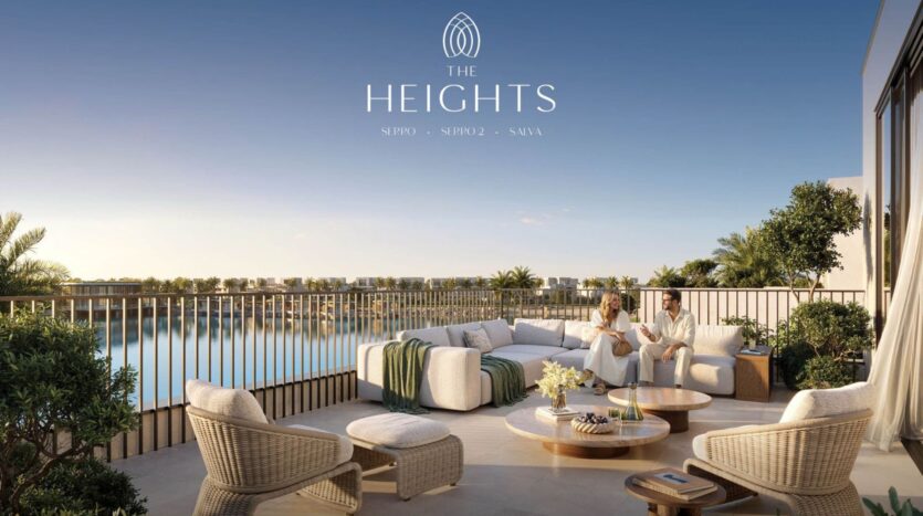 The luxurious outdoor terrace at The Heights hotel features cushioned seating, a coffee table, and lush plants overlooking a peaceful lake under clear skies. Two people relax on the sofa while "The Heights" appears above.