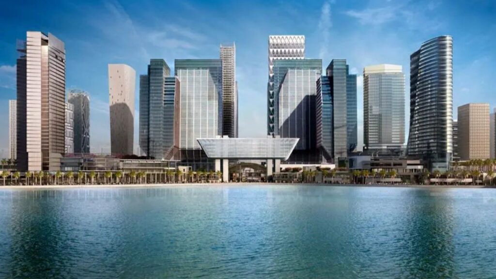 Un paysage urbain moderne d'Abu Dhabi avec de grands gratte-ciel en verre et des conceptions architecturales uniques, y compris l'extension ADGM, se reflétant dans une étendue d'eau calme sous un ciel bleu.