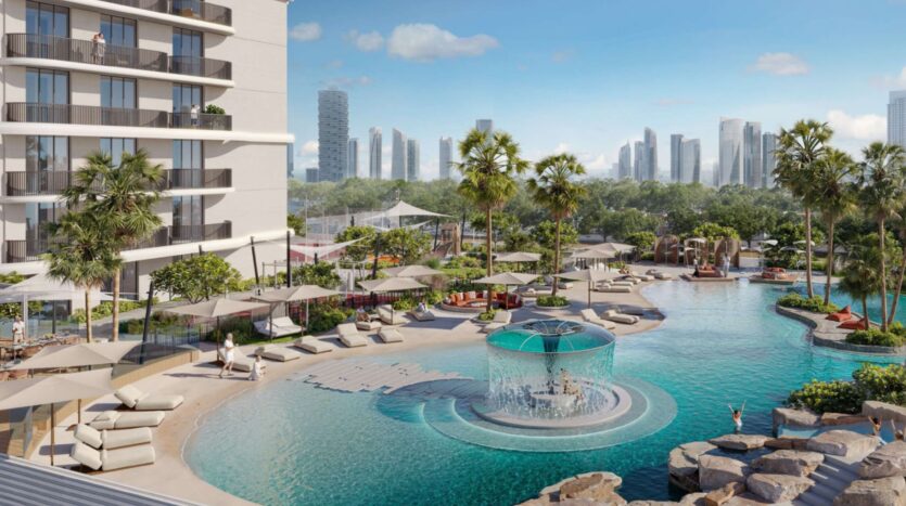 The luxurious pool at the Alta View complex, with its sun loungers, parasols, palm trees, and central fountain, is surrounded by a modern skyline and lush vegetation under a clear blue sky.