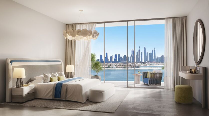 This modern room features a large Bella by Passo bed, an elegant chandelier, and floor-to-ceiling windows offering views of the city and waterfront. Light décor, a comfortable sitting area, and a vanity complete this stylish space.