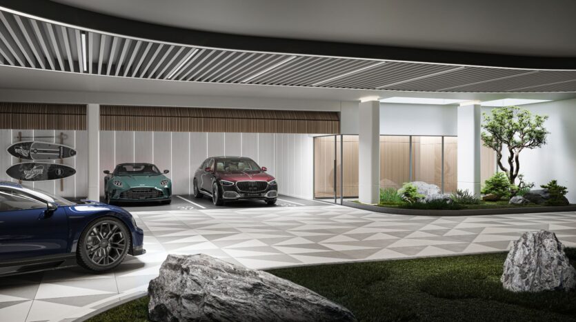 A modern indoor parking area featuring Bella by Passo, with three luxury cars parked, surfboards mounted on the wall, geometric floor tiles, a glass entrance, and a green space landscaped with rocks and a small tree.