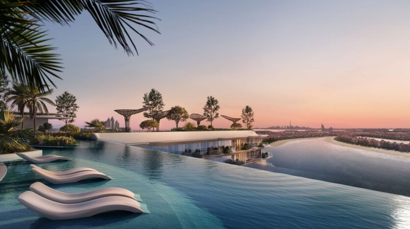 The infinity pool and white sun loungers at Bella by Passo overlook a picturesque river and the city skyline at sunset; palm trees and modern garden structures line the terrace, creating a luxurious and tranquil atmosphere.