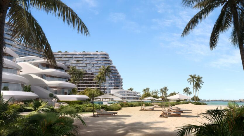 Bella by Passo is a modern seaside resort with curved white buildings, palm trees, sun loungers, and parasols on a sandy beach overlooking calm blue waters under clear skies.