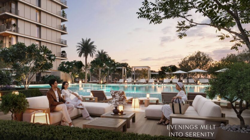 Un lujoso salón junto a la piscina al atardecer, con personas relajándose en modernos sofás al aire libre, rodeados de árboles y vegetación en Creek Bay. En el fondo se ven elegantes edificios. El texto dice: «LAS NOCHES SE FUNDEN EN SERENIDAD».