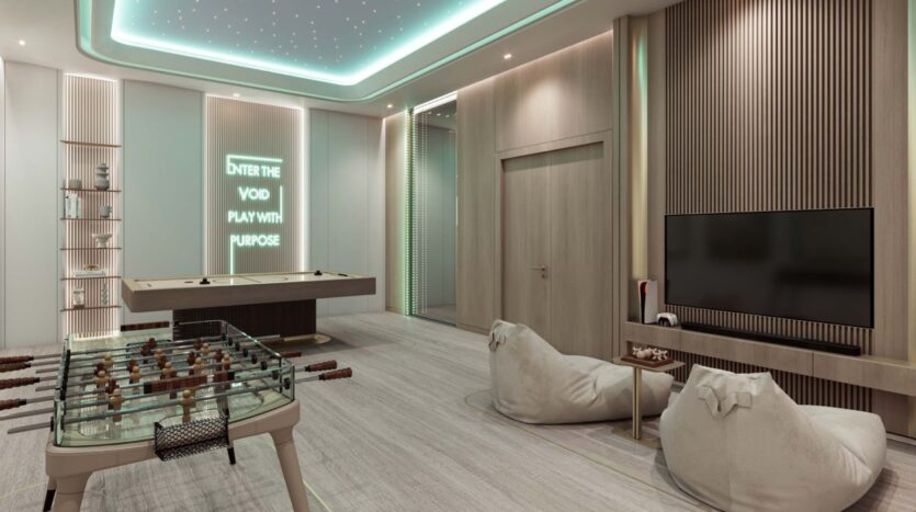 Modern game room in Flora Bay with foosball, air hockey, beanbag chairs, and a wall-mounted TV. A neon sign reads "ENTER THE VOID PLAY WITH PURPOSE." Wood accents and soft ceiling lighting complete the look.
