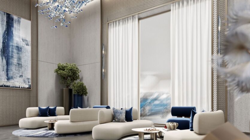 The modern living room of the Inara residence, with its cream and navy blue furnishings, abstract artwork, decorative greenery, blue chandelier, and large windows with sheer white curtains, creates an elegant and sophisticated atmosphere.