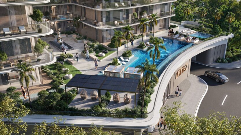 The infinity pool on the roof of the Inara residence invites you to relax amid palm trees, lounge chairs, and modern apartments with glass facades. Beneath the pool terrace, a car approaches the curved entrance for an elegant arrival.