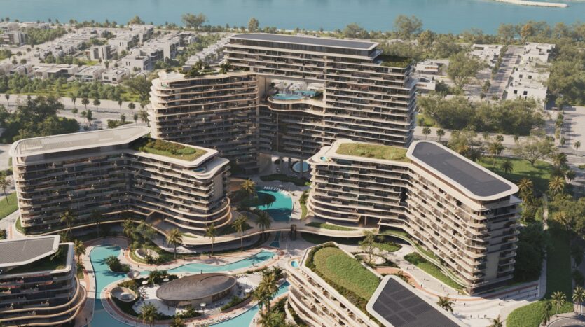Aerial view of modern, curved, multi-story buildings such as the Meriva, with rooftop gardens and swimming pools surrounded by palm trees, located near a river and a residential neighborhood with tree-lined streets.