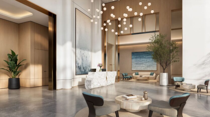 Spacious modern lobby of the Muheira Hotel with high ceilings, hanging globe lamps, marble reception desk, contemporary artwork, comfortable seating, potted plants, and large windows letting in natural light.