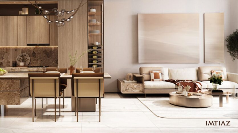 Modern living and dining room in soft shades of beige and brown in Sea Cliff, featuring a dining table with four chairs, wooden kitchen cabinets, a comfortable sofa, abstract artwork, and a round coffee table on a light-colored rug. "IMTIAZ" logo in the corner.