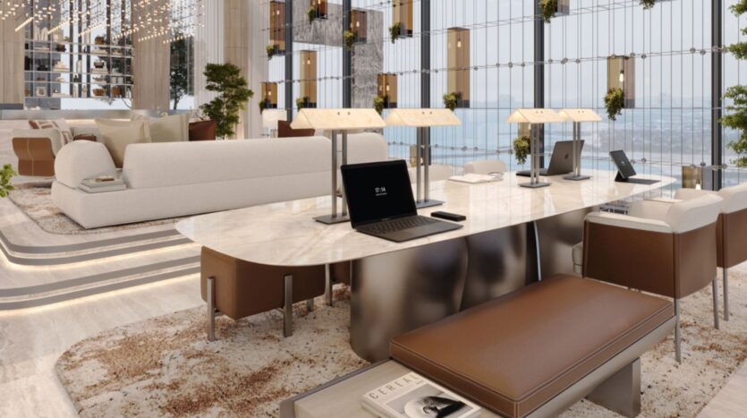 Sea Cliff's modern and luxurious lounge features marble tables, brown leather banquettes, beige sofas, and laptops on desks. Floor-to-ceiling windows offer views of the city; greenery and sleek lighting add elegance to this open and bright space.