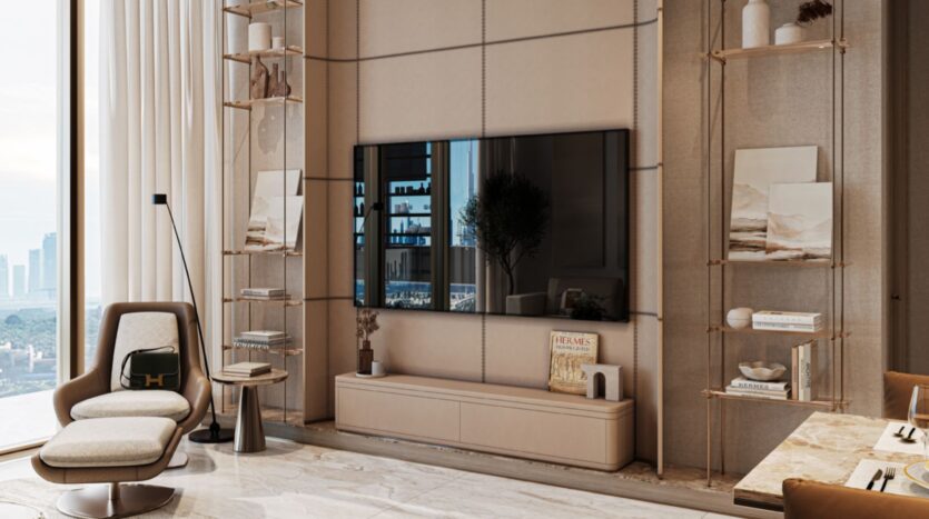 Modern living room in Sea Cliff with a large wall-mounted television, shelves for books and decorations, a beige armchair next to a side table, a floor lamp, marble flooring, and a view of the city through a large window. Neutral tones and minimalist design define the space.