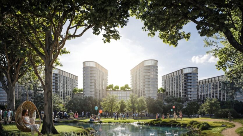 Sobha Sanctuary is a modern residential complex consisting of tall, curved buildings surrounding a lush park with a pond, tree-lined paths, and children playing with balloons. In the foreground, a person relaxes in a chair suspended under a peaceful tree.