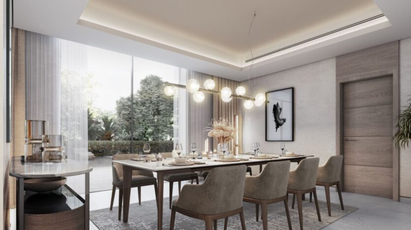 Modern dining room at Sobha Sanctuary with a long table for eight people, beige upholstered chairs, a contemporary chandelier, large windows with sheer curtains, and minimalist decor. A sideboard, abstract wall art, and indoor plants complete the space.
