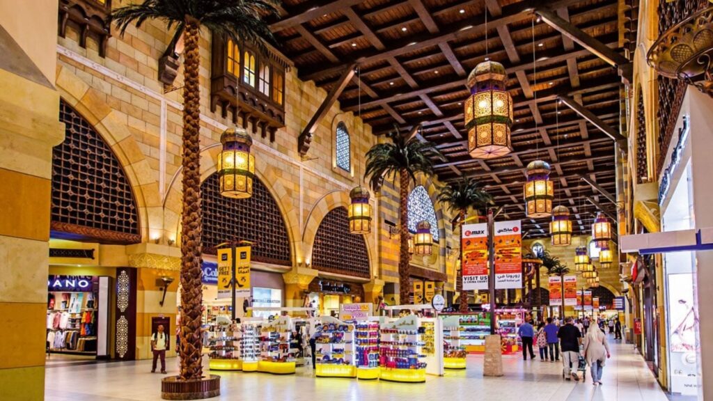 Ce centre commercial intérieur spacieux et dynamique s'inspire de l'architecture du Moyen-Orient, avec de hauts plafonds en bois, des lanternes ornées, des palmiers et des boutiques colorées. Il rappelle la grandeur des grands centres commerciaux de Dubaï, comme le Mall of the Emirates.