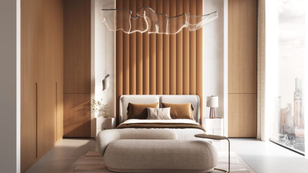 A modern Skyflame bedroom featuring an upholstered accent wall, a white bed with brown and white bedding, a curved bench, minimalist nightstands, a sculptural ceiling light, and large windows offering views of the city.